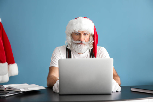 Santa Claus dolgozik laptop asztalnál - Fotó, kép