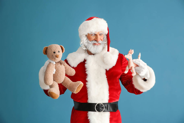 Retrato de Papai Noel com brinquedos sobre fundo de cor
 - Foto, Imagem
