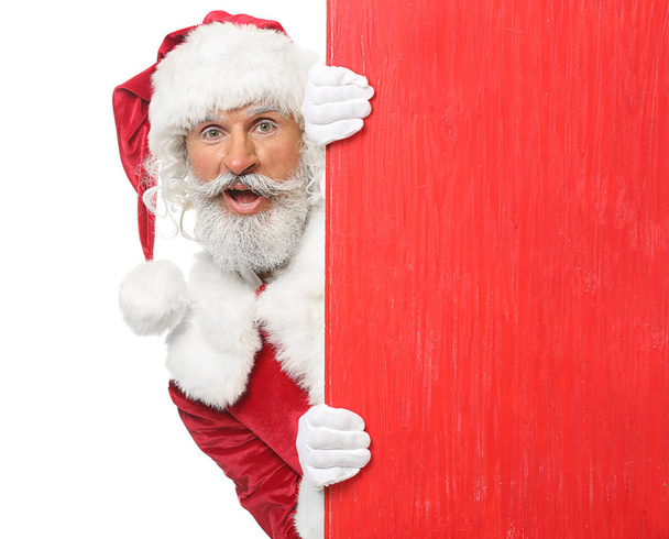 Portrait of Santa Claus with blank wooden board on white background - Photo, Image