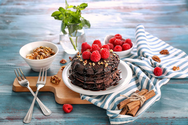 Composição com saborosas panquecas de chocolate e bagas na mesa de madeira
 - Foto, Imagem