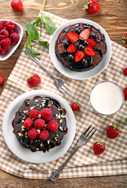 おいしいチョコレートのパンケーキ、果実、木のテーブルにミルクとプレート - 写真・画像