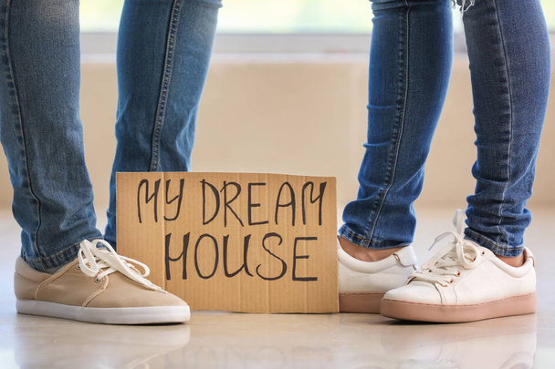 A fiatal pár és a karton lap szöveg My Dream House beltéri lábak - Fotó, kép