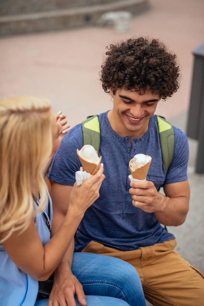 Young couple enjoying eating ice cream together in the city. - Φωτογραφία, εικόνα
