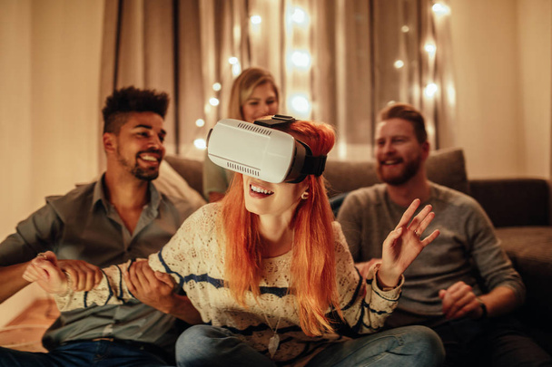 Friends having fun with virtual reality headset at home. - 写真・画像