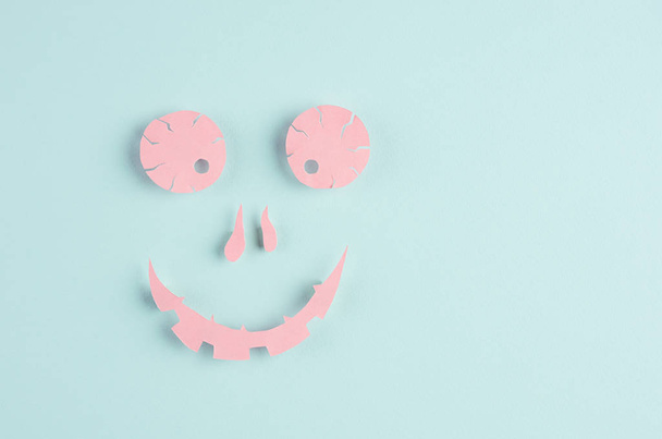 Halloween background - smile scary face monster of cut paper on mint background, copy space. - Фото, зображення