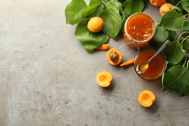 Glassware with sweet apricot jam and fresh fruit on table - Φωτογραφία, εικόνα
