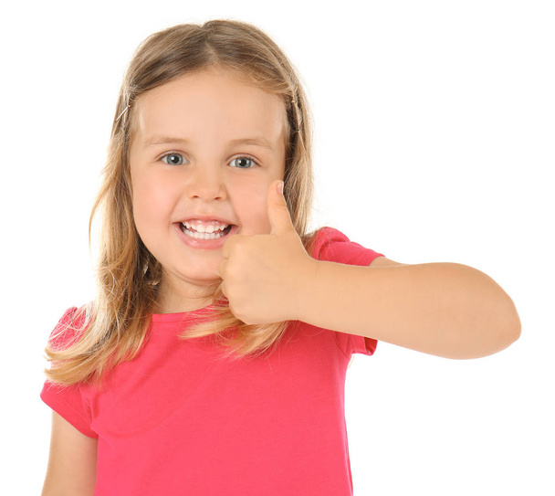 Nettes kleines Mädchen zeigt Daumen-hoch-Geste auf weißem Hintergrund - Foto, Bild
