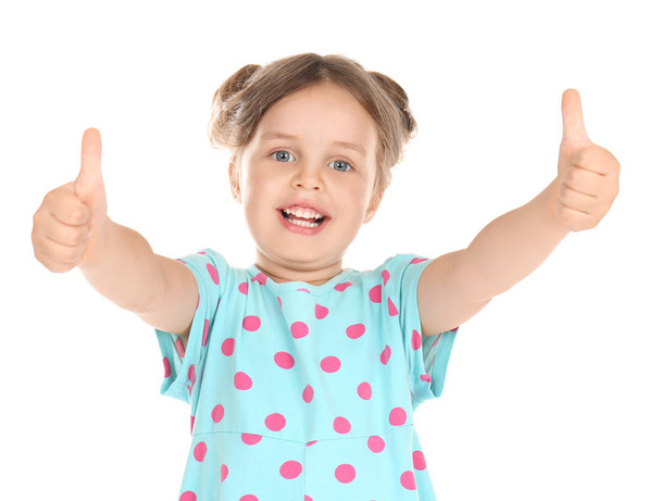 Cute little girl showing thumb-ups gesture on white background - Photo, Image