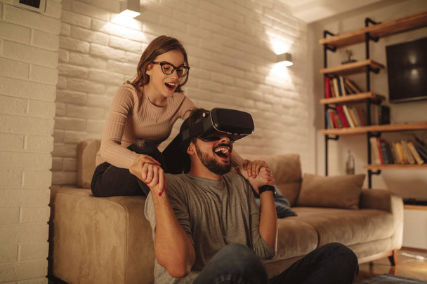 Young couple enjoying using in virtual reality headset. - Foto, afbeelding