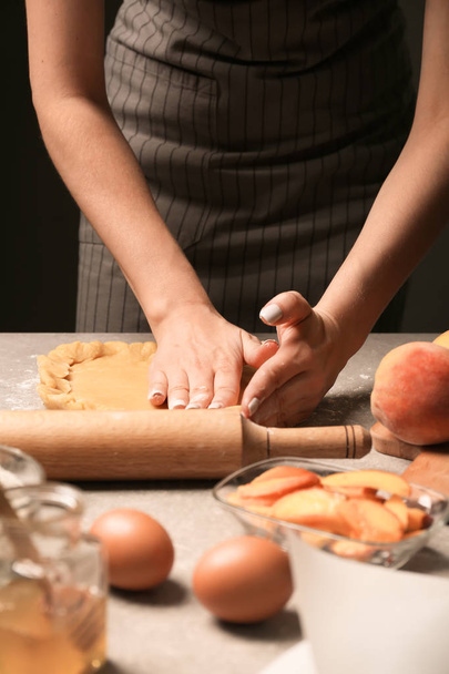Woman preparing dough for peach galette at table - Zdjęcie, obraz