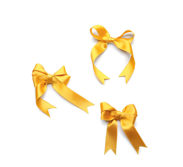 Beautiful bows made from golden ribbon on white background - Photo, Image