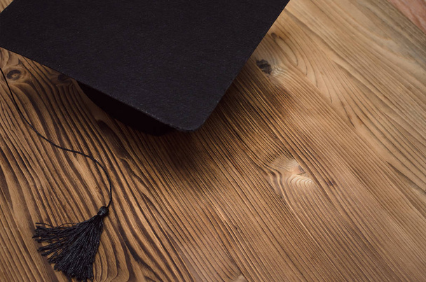 Graduate cap on the wooden school desk with copy space. - Foto, Imagem