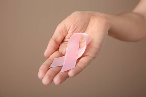 Kobieta trzyma różową wstążką na kolor tła, zbliżenie. Koncepcja raka piersi - Zdjęcie, obraz