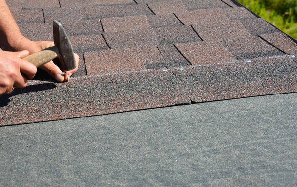 Roofing contractor installing roof tiles, asphalt shingles with copy space. - Foto, Imagen