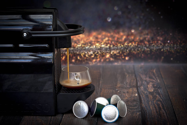 Espresso coffee maker and capsules on a wooden table - Photo, Image