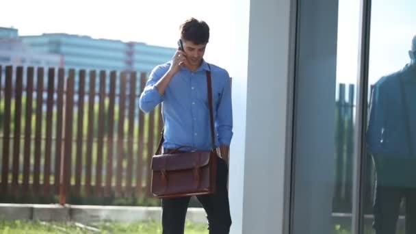 handsome young man walking and talking over cellphone - Filmmaterial, Video