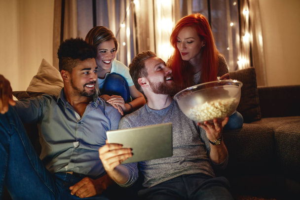 Friends watching a movie on digital tablet at home. - Foto, imagen