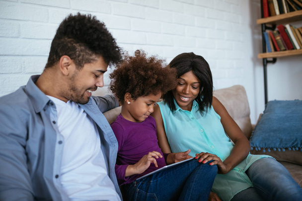 African american family using digital tablet at home. - Foto, Imagen