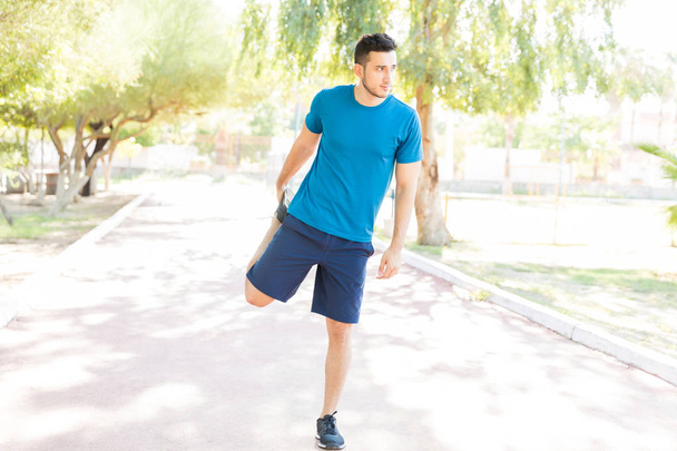 Teljes hossza nyújtás láb-Park Fitnesz edzés előtt a fiatalember - Fotó, kép