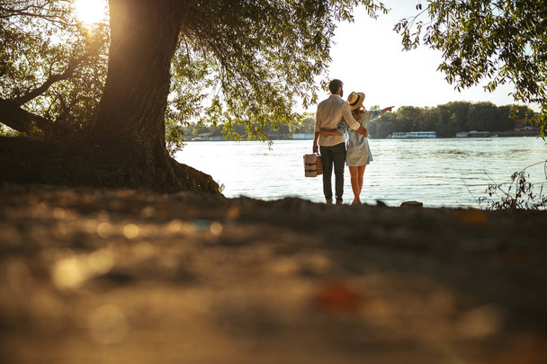 Rear view of a couple enjoying the view on the river. - Foto, Imagem
