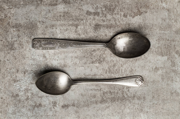 Two vintage spoons on a marble table - 写真・画像