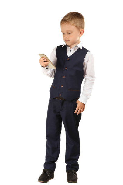 Schoolboy in classic suit with smartphone isolated on white. - Foto, afbeelding