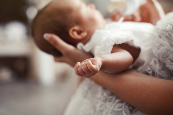 Retrato de cerca de la hermosa madre joven besando a su bebé recién nacido. Bebé recién nacido durmiendo. Mano de recién nacido. Mamá y su hijo. Concepto de familia feliz
. - Foto, imagen