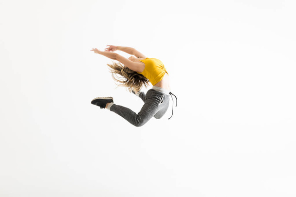 Θηλυκό διάλειμμα χορευτής δείχνει στα ανοικτά κάποια του χορού της κινείται πάνω από το λευκό φόντο - Φωτογραφία, εικόνα