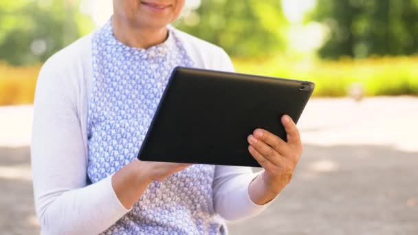 senior woman with tablet pc at summer park - Felvétel, videó
