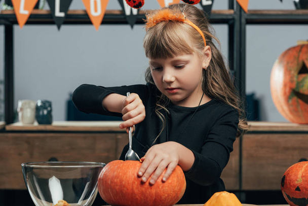 portret małego dziecka rzeźbienia dyni na halloween tylko przy stole w domu - Zdjęcie, obraz