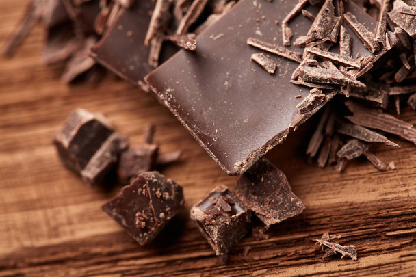 morzsa fekete csokoládé, egy fából készült háttér - Fotó, kép