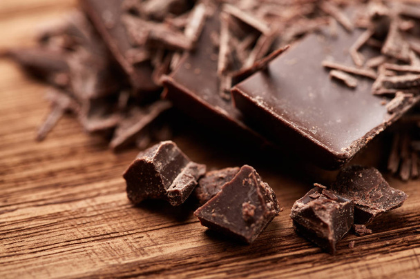 morzsa fekete csokoládé, egy fából készült háttér - Fotó, kép