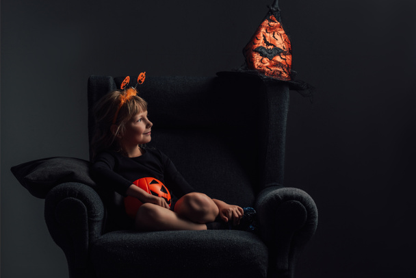 adorable kid in halloween costume resting in armchair at home - Photo, Image