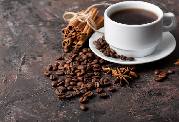 Coffee beans and cinnamon on a background of burlap. Roasted coffee beans background close up. Coffee beans pile from top with copy space for text. Seasoning. Spice. Cinnamon. Badian. Coffee house. - Φωτογραφία, εικόνα