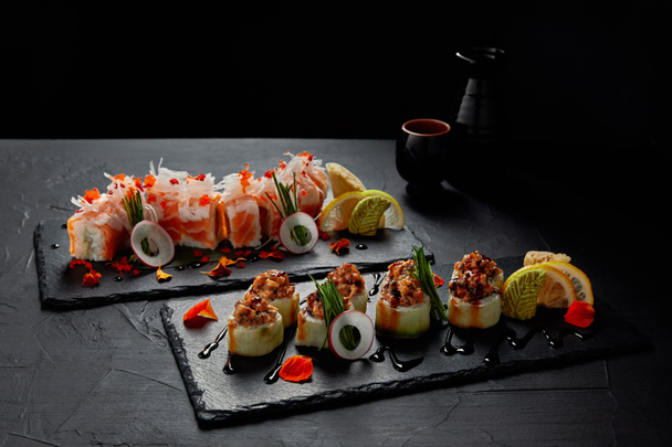 close-up view of delicious fresh traditional sushi rolls on slate boards - Photo, Image
