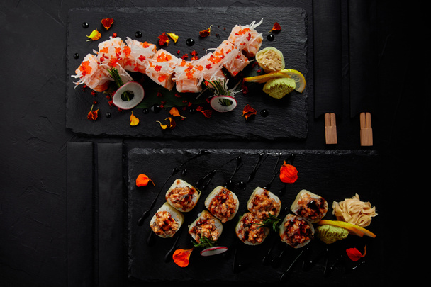 κάτοψη του ρολό σε mamenori με γαρίδες, σολομό και αβοκάντο στην σάλτσα nigiri και ρολό με κρεμώδη χελιού και kimchi μαγιονέζα  - Φωτογραφία, εικόνα