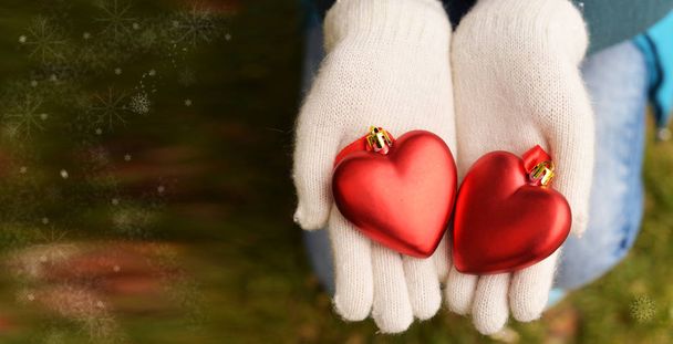 belle carte de vœux avec fille en gants mitaines blanches tenant des jouets sur arbre de Noël coeurs rouges en vacances en hiver nouvel an et Noël avec flocons de neige sur un fond vert
 - Photo, image