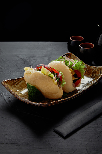 close-up view of fresh yummy buns with vegetables on plate - Photo, Image