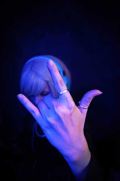 young DJ woman with white headphones on dark background - Valokuva, kuva