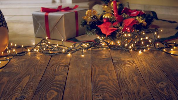 Imagen tonificada de tablas de lana vacías con brillantes luces de Navidad y regalos en backgorund
 - Foto, Imagen