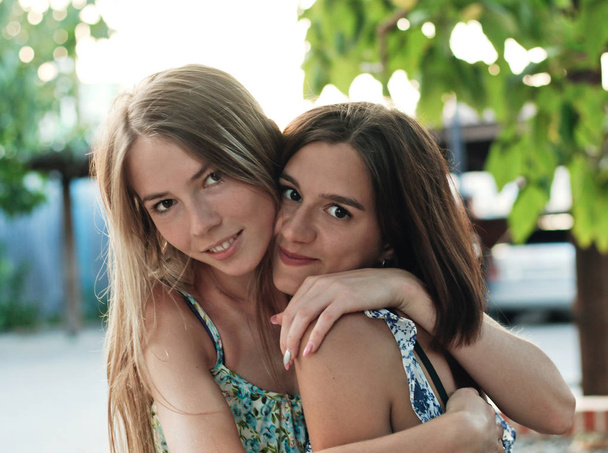 two cute girls holding each other in the street - Photo, Image