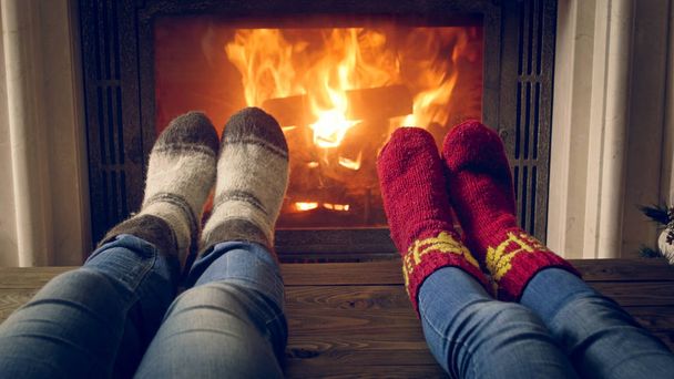 Tónovaný fotografie romantické rodiny nosí pletené vlněné ponožky oteplování na krb - Fotografie, Obrázek