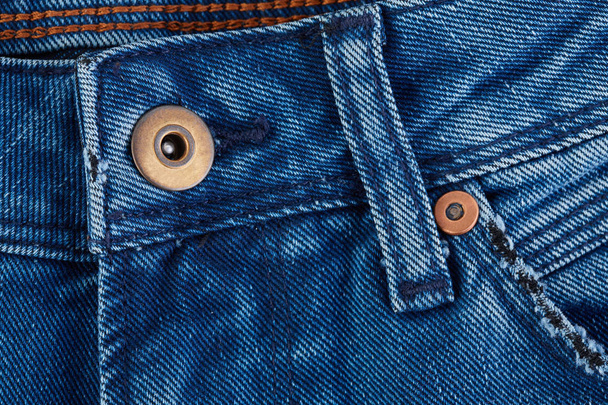 Denim jeans texture background with torn. The texture of the colored cotton fabric. Stitched texture jeans background. Fashion jeans button. Pocket and rivet on jeans. Fiber and fabric structure. - Φωτογραφία, εικόνα