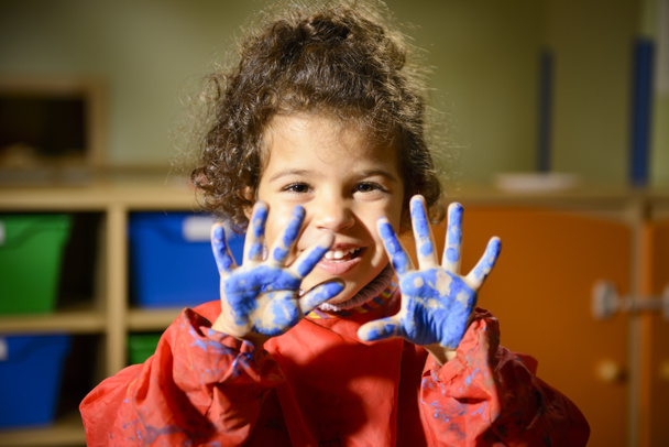 幼稚園での手で絵画の幸せな女の子 - 写真・画像