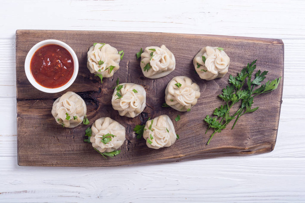 Georgian dumplings khinkali with tomato sauce and parsley - Fotografie, Obrázek