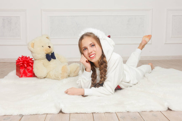 Merry Christmas and Happy New Year Beautiful happy child girl in pajamas waiting for a miracle at home with Christmas tree. Little smiling girl with christmas gift box. Holiday and people concept. - Foto, Imagem