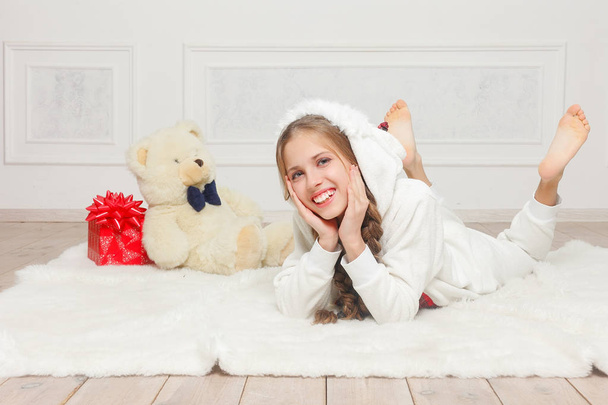 Merry Christmas and Happy New Year Beautiful happy child girl in pajamas waiting for a miracle at home with Christmas tree. Little smiling girl with christmas gift box. Holiday and people concept. - Photo, image