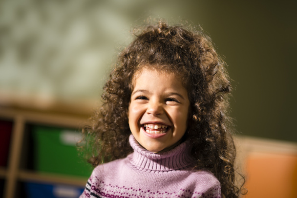 ευτυχισμένη γυναίκα παιδί, χαμογελώντας για χαρά στο νηπιαγωγείο - Φωτογραφία, εικόνα