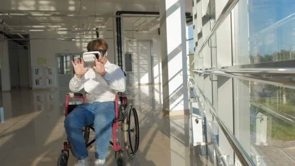 инвалид на инвалидной коляске у окна использует шлем виртуальной реальности
 - Кадры, видео