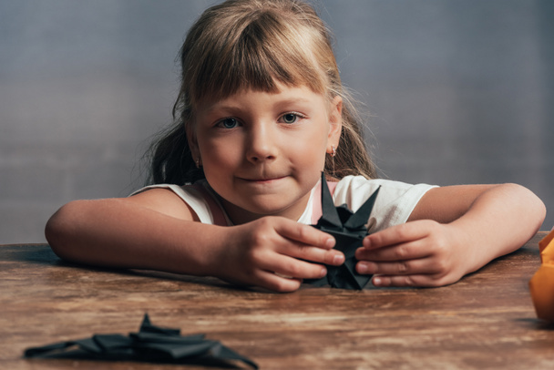 Portret van klein kind met vleermuizen van zwart papier camera thuis kijken - Foto, afbeelding